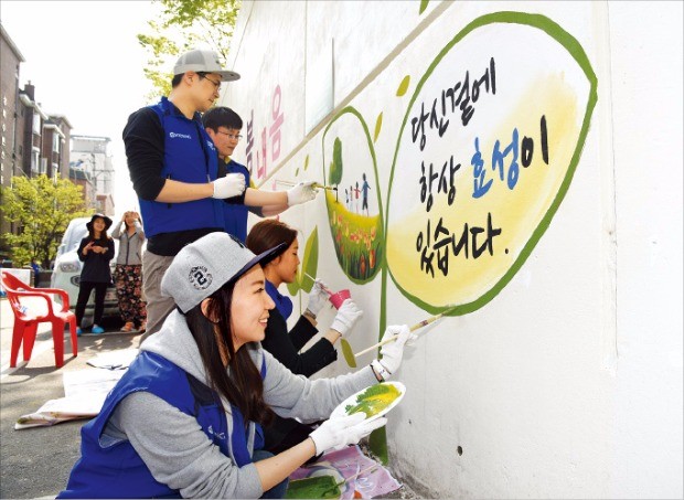 지난해 4월 효성 중공업PG와 협력사 직원들이 서울시 망원동 일대에서 ‘안전마을 만들기’ 프로젝트로 벽화 그리기 봉사활동을 하고 있다. 