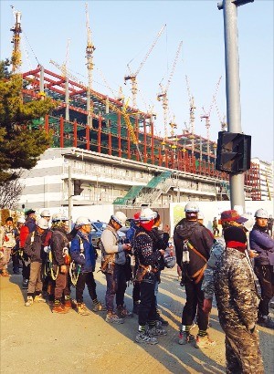 경기 파주 LG디스플레이 공장 증설 현장에서 퇴근 버스를 기다리고 있는 건설 근로자들. 뒤로 보이는 건설 중인 공장은 넓이 382m×265m에 높이 100m 이상으로 축구장 14개 규모다. 파주=박재원 기자