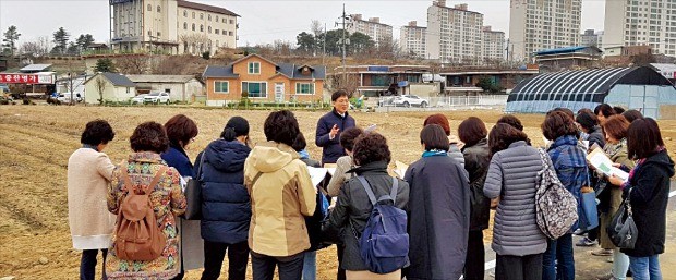 지난 20일 강원 원주시에서 열린 ‘부동산 필드아카데미’에 참가한 수강생들이 고준석 신한은행 부동산투자자문센터장의 설명을 들으며 주변 땅을 살펴보고 있다.  김형규  기자 