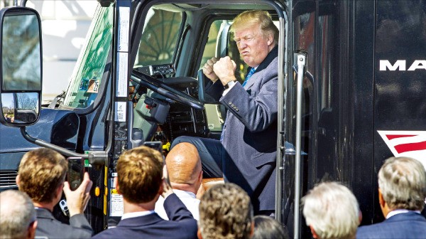 < 힘 과시?…트럭 탄 트럼프 > 도널드 트럼프 미국 대통령이 23일(현지시간) 트럭운송회사 최고경영자(CEO)들과 트럭 운전기사들을 워싱턴DC 백악관으로 초청해 만난 자리에서 대형 트럭에 올라 주먹을 불끈 쥐고 있다. 트럼프 대통령은 바퀴가 18개 달린 트럭의 운전석에 앉아 경적을 울려대고 익살맞은 표정을 지으며 트럭을 운전하는 듯한 ‘연기’도 선보였다. 워싱턴AP연합뉴스