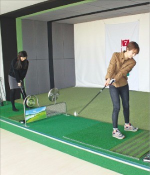 HK의 체력단련장에서 직원들이 점심식사 후 골프연습을 하고 있다. 