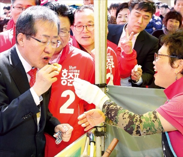 홍준표 자유한국당 대선후보가 18일 울산 남창시장에서 상인이 준 국화빵을 먹고 있다. 연합뉴스