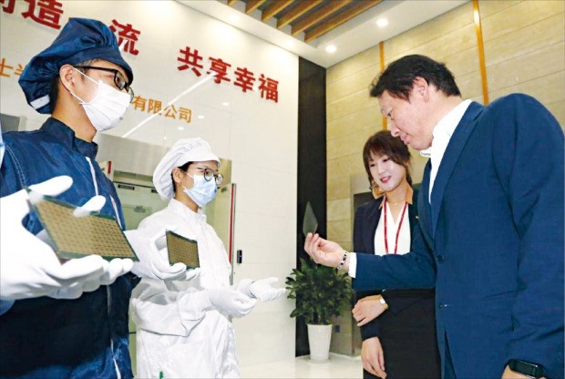 최태원 SK그룹 회장(오른쪽)이 지난해 9월 SK하이닉스 중국 충칭 공장을 방문해 생산 중인 반도체 제품을 살펴보고 있다. SK그룹 제공