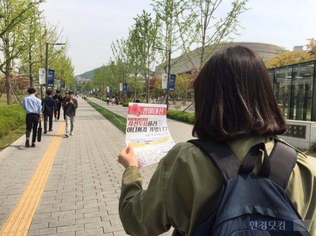 4일 오전 연세대학교 백양로에서 '5‧9장미대선' 사전투표 안내 용지를 읽고 있는 한 학생.