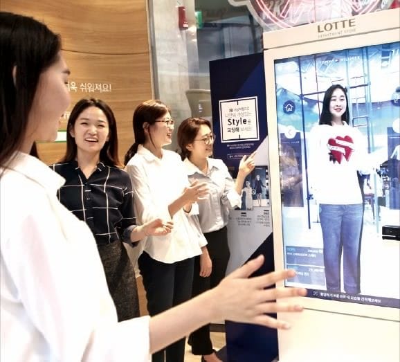 롯데백화점이 작년 9월 도입한 3차원(3D) 가상 피팅 서비스를 체험해보기 위해 한 고객이 디지털 거울 앞에 서 있다. 롯데백화점  제공 