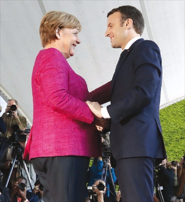 앙겔라 메르켈 독일 총리(왼쪽)와 에마뉘엘 마크롱 프랑스 대통령이 15일(현지시간) 독일 베를린 총리관저에서 손을 잡으며 인사하고 있다. 베를린AFP연합뉴스