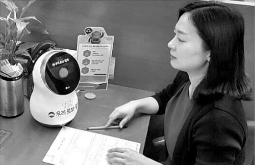 안상미 한국경제신문 기자가 25일 서울 소공로 우리은행 본점에서 금융권 최초로 도입된 ‘로봇 은행원’에게 자산관리 상담을 받고 있다. 김범준 기자 bjk07@hankyung.com