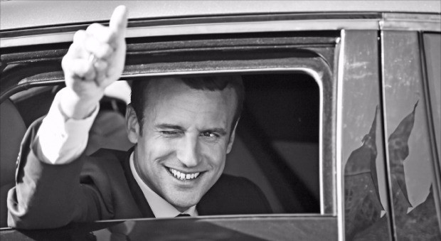 에마뉘엘 마크롱 프랑스 대통령이 총선 결선투표가 치러진 18일(현지시간) 투표소로 향하면서 차창 밖으로 손을 내밀어 엄지손가락을 세워 보이고 있다. 투케AFP연합뉴스