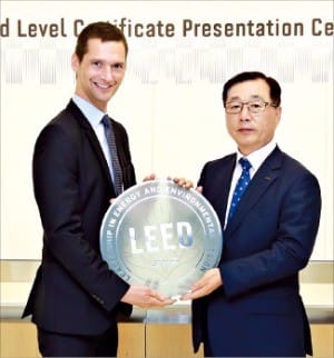 박현철 롯데물산 대표(오른쪽)가 피터 탬플레튼 미국 그린빌딩협의회(USGBC) 수석부의장에게 인증패를 받고 있다. 롯데물산 제공
 