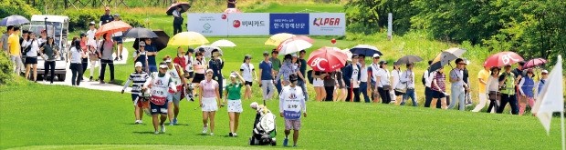 ‘비씨카드·한경레이디스컵 2017’ 첫째날인 22일 경기 안산시 아일랜드CC 5번홀에서 김해림(왼쪽부터) 김지현 오지현이 티샷 후 캐디들과 함께 그린으로 가고 있다. 갤러리들도 필드 옆 도로를 따라 그린을 향해 걸어가고 있다. 이승재 한경매거진 기자 fotoleesj@hankyung.com