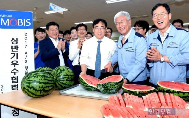 경기도 안산에 소재한 ㈜대원산업에서 현대모비스가 수박을 나누는 모습. 현대모비스 통합구매담당 조성진 이사(앞줄 가운데)와 대원산업 허재명 대표이사(오른쪽 두 번째)가 밝게 웃고 있다. (사진=현대모비스)