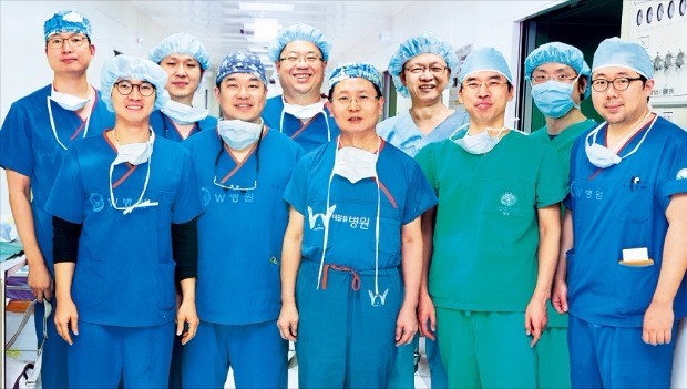 우상현 대구 W병원 병원장(앞줄 가운데)이 지난 2월 국내 최초로 팔 이식 수술에 성공한 뒤 의료진과 함께 기념촬영하고 있다. W병원  제공