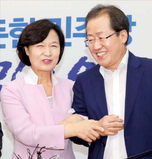 < 사시 동기생 ‘어색한 팔짱’ > 추미애 더불어민주당 대표(왼쪽)가 4일 국회 대표실을 방문한 홍준표 자유한국당 대표와 대화하던 중 “협치를 국민 앞에 약속한다는 의미에서 팔짱 한번 끼실까요”라며 홍 대표와 팔짱을 끼고 있다. 두 사람은 사법시험 24회(사법연수원 14기) 동기다.  연합뉴스 