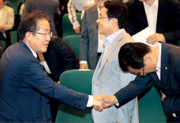 홍준표 자유한국당 대표(왼쪽)와 이현재 정책위원회 의장이 6일 국회 도서관에서 열린 국회의원-당협위원장 연석회의에서 악수하고 있다.   연합뉴스 