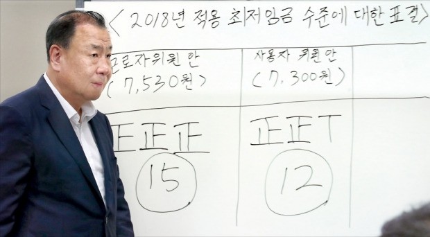 어수봉 최저임금위원장이 지난 15일 내년도 최저임금이 시간당 7530원으로 확정됐다고 발표한 뒤 회의장을 나서고 있다.  연합뉴스 