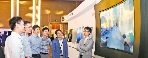 지난 8일 중국 베이징에서 열린 ‘제2회 커브드 포럼’에 참석한 관람객들이 상하좌우 네 면이 휜 삼성디스플레이의 ‘S커브드 LCD’ 제품을 살펴보고 있다.  삼성디스플레이 제공 