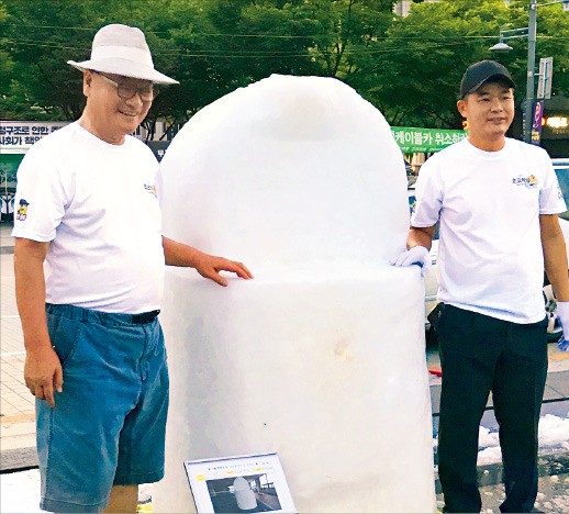 윤영달 크라운해태제과 회장(왼쪽)이 지난 12일 서울 광화문광장에서 열린 ‘한여름밤 눈조각전’에서 한 직원의 작품을 감상한 뒤 사진을 찍고 있다. 김보라 기자