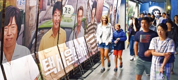 20일 서울 용산CGV에서 관객들이 올 들어 처음 1000만 명을 돌파한 영화 ‘택시운전사’ 포스터 앞을 지나고 있다. 허문찬 기자 sweat@hankyung.com 