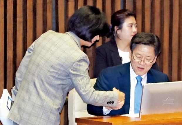 < 국민의당 찾아간 추미애 > 추미애 더불어민주당 대표(왼쪽)가 14일 교육·사회·문화분야 대정부질문이 열린 국회 본회의장에서 주승용 국민의당 의원 자리로 찾아가 악수하고 있다.  /연합뉴스 