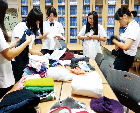  학생들이 교내에서 기증받은 의류를 옷캔에 전달하기 위해 상자에 담고 있다. 옷캔 제공 