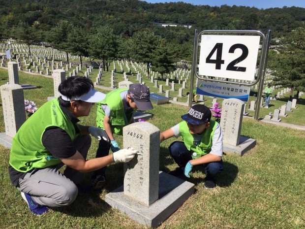 ‘제 69주년 국군의 날’을 앞두고 국립서울현충원 묘역정화 봉사활동에 참여한 현대엔지니어링 임직원과 가족들이 42번 묘역에 안치된 한국전쟁 전사자 묘비를 정성스럽게 닦고 있다.
