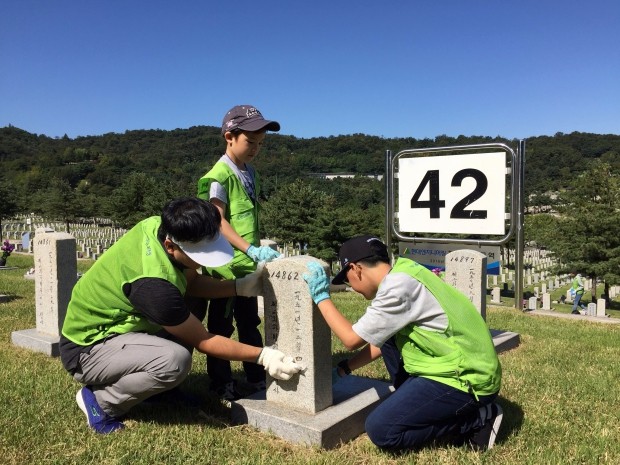 ‘제 69주년 국군의 날’을 앞두고 국립서울현충원 묘역정화 봉사활동에 참여한 현대엔지니어링 임직원과 가족들이 42번 묘역에 안치된 한국전쟁 전사자 묘비를 정성스럽게 닦고 있다.
