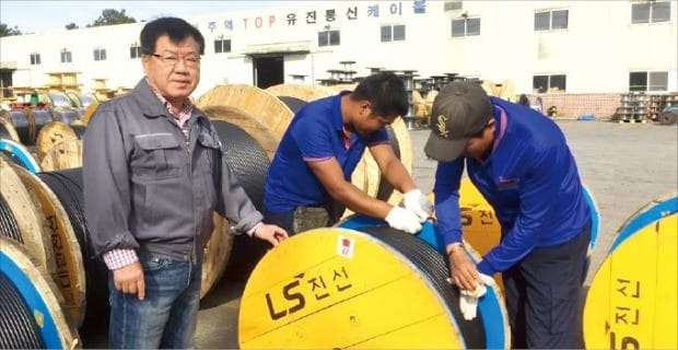 정태봉 유진통신공업 사장이 세종시에 있는 본사 공장에서 LS전선에 납품할 케이블 제품을 직원들과 함께 살펴보고 있다.  /노경목 기자 