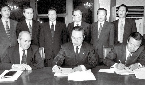 1997년 12월3일, 국제통화기금(IMF) 구제금융 합의서에 서명하고 있는 임창열 경제부총리(가운데)와 이경식 한국은행 총재(오른쪽). 왼쪽은 미셸 캉드쉬 IMF총재.  /한경DB