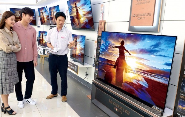 소비자들이 LG전자 가전 매장에서 ‘LG 올레드TV’를 살펴보고 있다. 올레드 TV는 LCD TV와 달리 소자 하나하나가 백라이트 없이 자체 발광하기 때문에 화질이 선명하다. LG전자  제공 