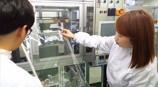 코오롱인더스트리 연구원들이 세계 최초로 개발한 투명폴리이미드 필름인 CPI필름을 점검하고 있다. 코오롱인더스트리 제공 