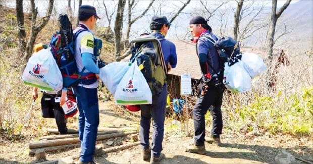 윤진하 블랙야크 셰르파가 팀을 꾸려 산에 버려진 쓰레기를 줍고 있다. 윤씨는 쓰레기 줍는 환경 봉투를 ‘복주머니’라고 부른다. 블랙야크 제공
 