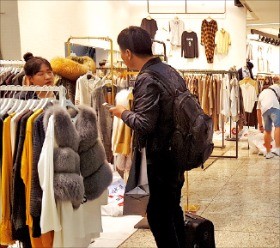서울 신당동 DDP패션몰에서 한 남성이 여성복 도매의류매장에서 직원에게 문의하고 있다. 
