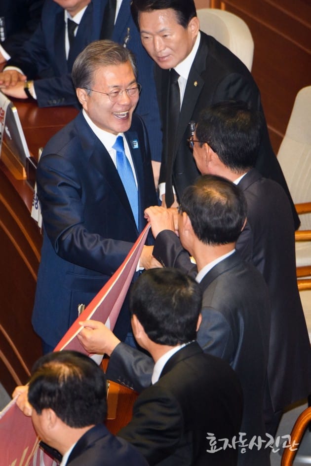 현수막을 들고 시위하는 자유한국당 의원들에게 악수를 요청하는 문재인 대통령. 사진=대통령 경호처