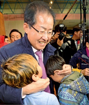 홍준표 자유한국당 대표가 16일 경북 포항시 흥해읍 흥해실내체육관에 마련된 지진 대피소를 방문해 아이들을 위로하고 있다. 연합뉴스