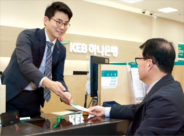 KEB하나은행 직원(왼쪽)이 27일 서울 을지로 본점 창구에서 고객에게 상품을 설명하고 있다.  /KEB하나은행 제공 