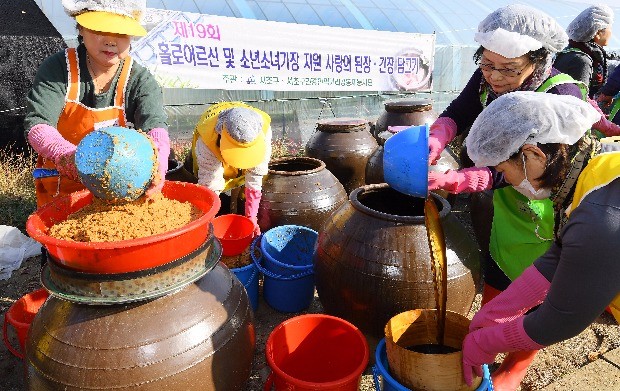 서울 서초구청이 9일 서울 원지동 대원주말농장에서 개최한 '사랑의 된장, 간장 담그기 행사'에 참가한 자원 봉사자들이 저소득 독거 어르신, 소년소녀가장 등 300여 세대에 전달할 된장과 간장을 용기에 옮겨 담고 있다. 강은구기자 egkang@hankyung.com