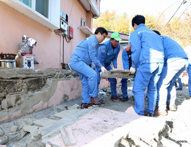 포스코 임직원들이 포항 지진으로 피해를 입은 주택가 현장을 찾아 건물 잔해를 옮기고 있다.