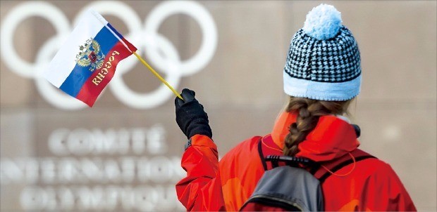 스위스 로잔에서 열린 국제올림픽위원회(IOC) 집행위원회 회의 첫날인 5일(현지시간) 한 여성이 IOC 본부 건물 앞에서 러시아 국기를 흔들고 있다. 러시아 선수들은 이날 IOC의 러시아 선수단 평창동계올림픽 출전 금지 결정에도 불구하고 개인 자격 출전은 허용됐다. AP연합뉴스 