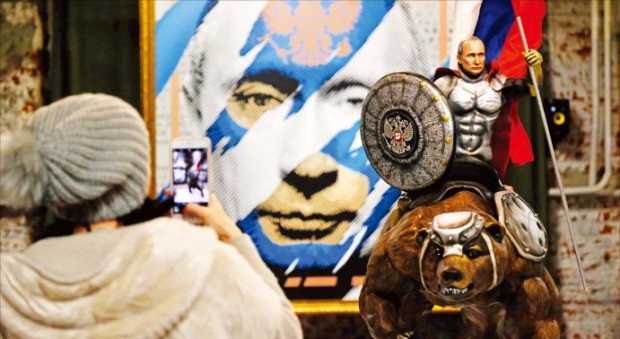 6일(현지시간) 러시아 모스크바 현대미술관(UMAM)에서 열린 ‘슈퍼푸틴’ 전시회를 찾은 한 방문자가 블라디미르 푸틴 대통령을 본떠 만든 조각상의 사진을 찍고 있다.  /모스크바AFP연합뉴스 