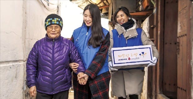 삼성전자 임직원들이 지난 6일 서울 동대문 쪽방촌을 방문해 쪽방에 거주하는 노인들에게 전달할 생필품 세트를 나르고 있다.  