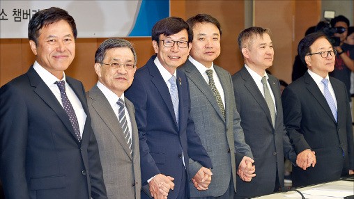 김상조 공정거래위원장(왼쪽 세 번째)이 지난 6월 대한상공회의소에서 열린 4대 그룹 정책간담회에서 참석자들과 손을 잡고 있다.  /한경DB 