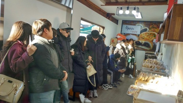 전주한옥마을에서 전주비빔빵을 사기 위해 줄을 서서 기다리는 관광객들.