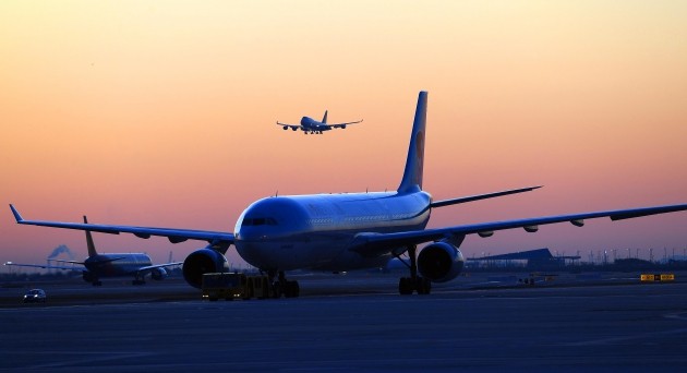 인천국제공항 제2여객터미널 계류장에서 바라본 아침 해가 붉게 떠오르고 있다. 인천국제공항 제2여객터미널(T2)은 2018년 1월18일 개항을 앞두고 있다. 인천공항은 총 4.9조 원을 투입해 제2여객터미널과 연계 교통시설 등을 신축하는 3단계 건설사업을 2009년부터 추진해왔으며, 제2여객터미널이 문을 열면 연간여객처리능력은 현재의 5,400만 명에서 7,200만 명으로 늘어난다. T2는 항공 동맹 스카이팀(대한항공·델타·에어프랑스·KLM) 탑승객을 위한 별도의 터미널로, 스타얼라이언스(아시아나항공)와 외항사, 저비용항공사 탑승객은 기존의 여객터미널(T1)을 이용하면 된다./김범준기자bjk07@hankyung.com