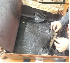 여행용 가방 안쪽에 은닉한 코카인을 확인하고 있는 검찰 수사관