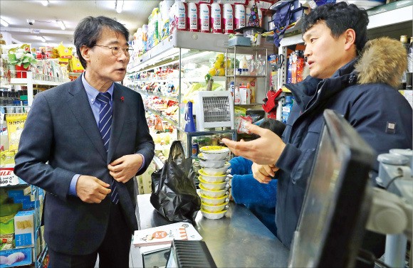 장하성 청와대 정책실장(왼쪽)이 18일 서울 신림동 상점가를 방문해 최저임금 인상과 관련한 상인의 의견을 듣고 일자리안정자금에 대해 설명하고 있다.  /청와대 제공 