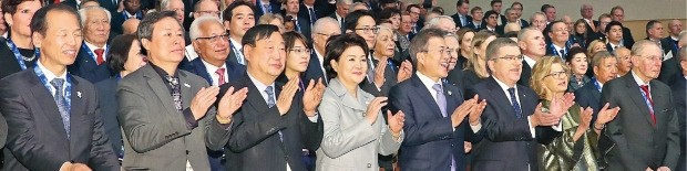 문재인 대통령과 부인 김정숙 여사가 5일 강원 강릉아트센터에서 열린 국제올림픽위원회(IOC) 총회 개회식에서 토마스 바흐 IOC 위원장, 이희범 평창동계올림픽 조직위원장 등과 올림픽 찬가를 부르고 있다. 왼쪽부터 최문순 강원지사, 도종환 문화체육관광부 장관, 이 위원장, 김 여사, 문 대통령, 바흐 위원장 부부, 자크 로게 전 IOC 위원장.  /연합뉴스 