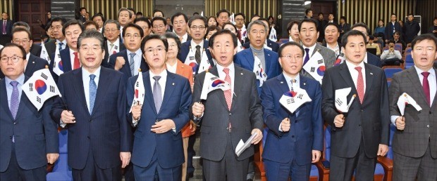 김성태 자유한국당 원내대표 등 한국당 의원들이 22일 의원총회에서 태극기를 흔들며 북한 김영철의 평창동계올림픽 폐회식 참석을 반대하는 구호를 외치고 있다. 앞줄 왼쪽부터 이채익·강석호·김태흠 의원, 김 원내대표, 윤재옥·박대출·민경욱 의원. 연합뉴스