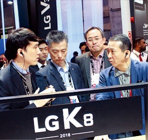 MWC에서 권영수 LG유플러스 부회장(오른쪽 첫 번째)이 황정환 LG전자 MC사업본부장(세 번째) 등과 함께 LG전자의 실속형 스마트폰 K8에 대해 설명을 듣고 있다.  /연합뉴스 