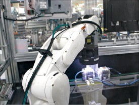 시각 센서를 갖춘 로봇이 완성품에 빛을 비춰 불량 여부를 검사하고 있다. 