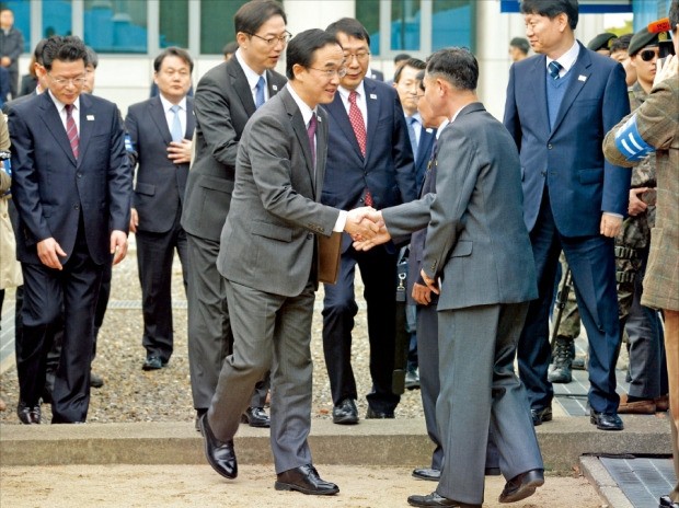 < 군사분계선 넘어가는 조명균 장관 > 조명균 통일부 장관(왼쪽)이 29일 판문점 북측 통일각에서 남북 고위급회담을 하기 위해 군사분계선을 넘어가 북측 대표단과 악수하고 있다.  /사진공동취재단 